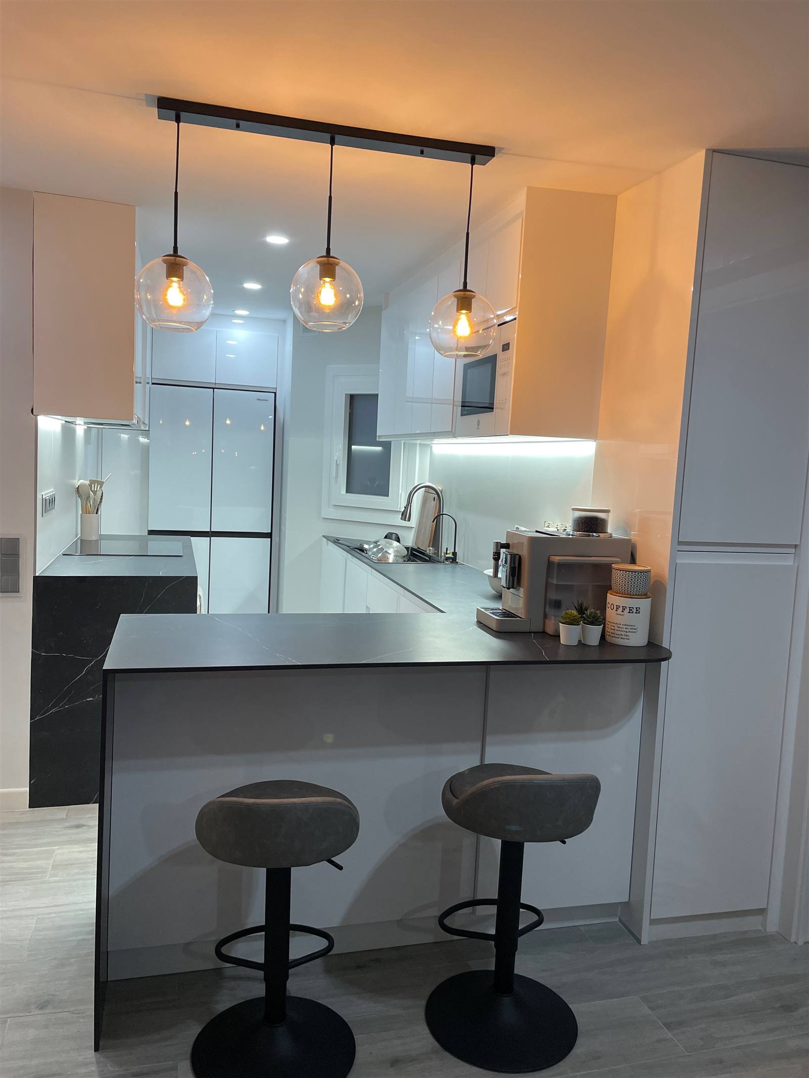 Reforma integral de cocina en Premià de Mar — isla con encimera, iluminación y acabados de calidad